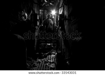 Muscular man is standing in the dark  industrial place
