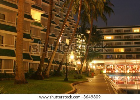 Swimming pool, night, hotel and palm trees
