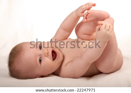 happy small baby isolated on white, playing with own legs