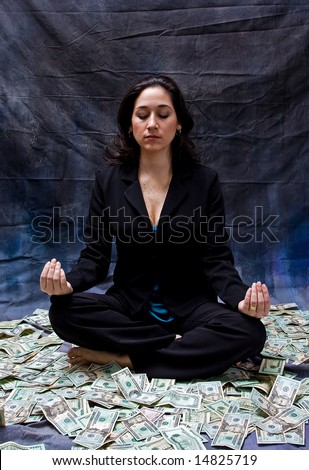 Rich woman meditating while sitting in money isolated on a dark background