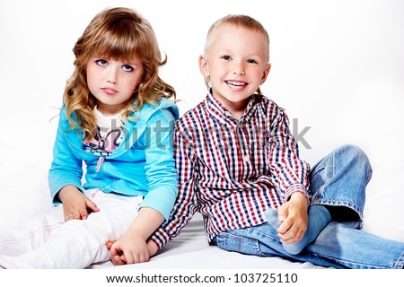 Portrait of beautiful  young little children girl with hairstyle and bright makeup in bright cloth ad attractive boy