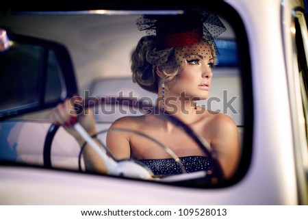 Portrait of beautiful sexy fashion girl model with bright makeup in retro style sitting in old car