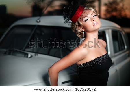 fashion portrait of beautiful sexy woman model girl posing standing near old car in retro style with bright makeup at sunset
