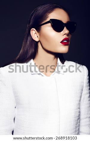 High fashion look.glamor closeup portrait of beautiful sexy stylish brunette young woman model with bright makeup with red lips in white coat jacket in sunglasses