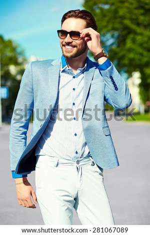 High fashion look.Young stylish confident happy handsome businessman model  in suit  lifestyle in the street in sunglasses