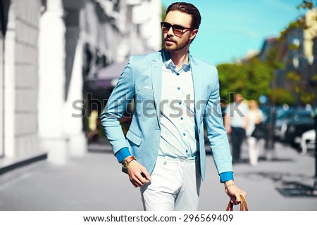 High fashion look.Young stylish confident happy handsome businessman model  in suit cloth lifestyle in the street in sunglasses