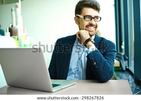 Young fashion smiling hipster man  in the city cafe during lunch time with notebook in suit