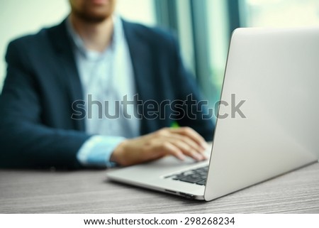 Young man working with laptop, man\'s hands on notebook computer, business person at workplace