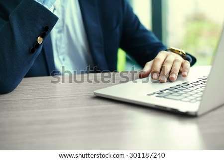 Young man working with laptop, man\'s hands on notebook computer, business person at workplace