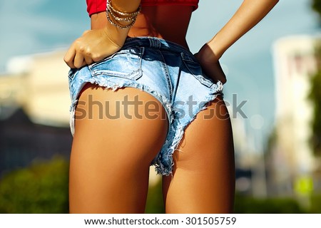 Sexy perfect female woman buttocks ass on blue sky city outdoors background in jeans shorts