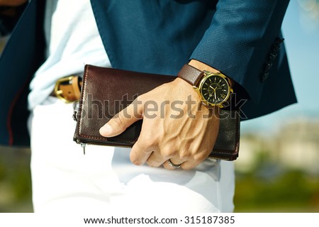 Fashion portrait of young businessman handsome model man in casual cloth suit with accessories on hands