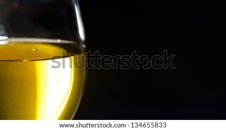 White wine in glass, black background