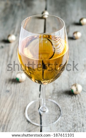 Wineglass with white wine and chocolate candies behind