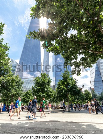 NEW YORK - JULY 17: People walk near Freedom Tower (1 WTC) in Manhattan on July 17, 2014. One World Trade Center is the tallest building in the Western Hemisphere.