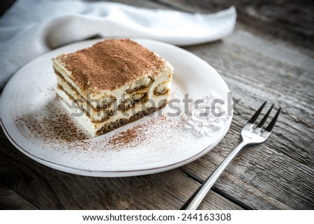 Tiramisu in the plate on the wooden background