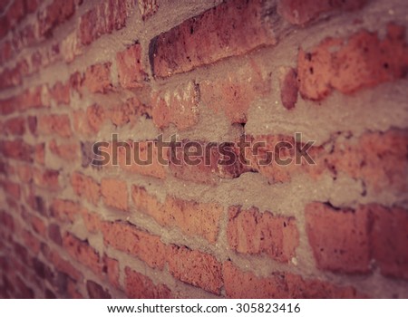 Old brick wall background in vintage filter effect. Selective focus