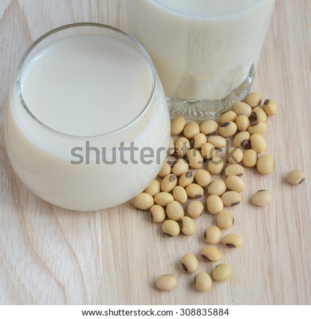 Fresh Soy milk (Soya milk) and dried soybean seeds on wooden background. Traditional staple of East Asian cuisine