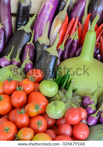Assortment of fresh vegetable (purple egg plant, tomato, Thai eggplant, bottle gourd, red hot chili and tomato) in wooden box