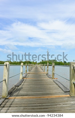 Long wood bridge over a river in low angle view
