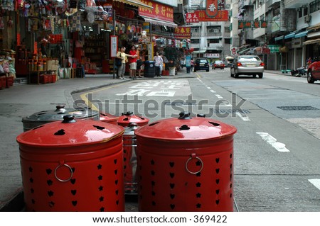 red paper money burning pots along a street in hong kong