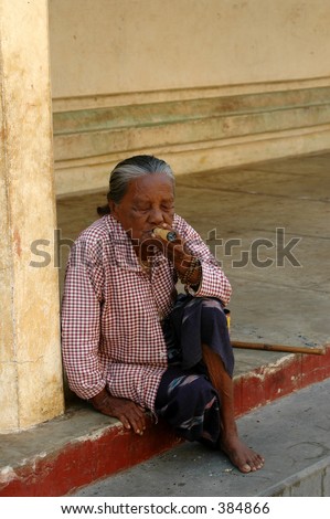 Old woman smoking a very large cheroot in Bagan, Burma (Myanmar)