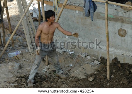 Construction worker tossing rocks on a building site in hong kong