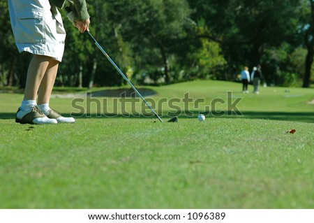 Golfer about to tee off on the golf course with an iron
