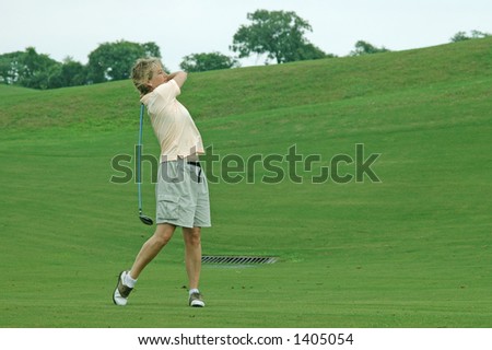 woman golfer at the end of her swing having taken a shot on the fairway