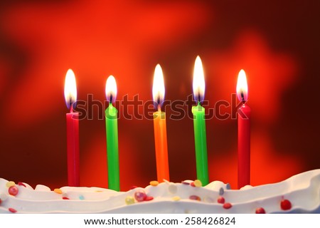 Five lit birthday candles close up, shallow dof