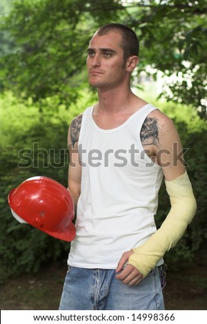 tattooed man with red helmet and hand in plaster
