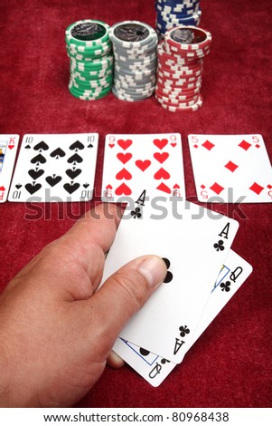 Man hand holding two cards in a game of poker