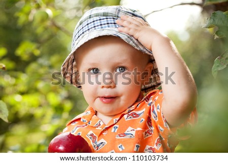 Kid in panama with red ripe apple