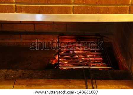 The heated lattice for preparation of vegetables, meat and fish a grill on a brazier with burning coals