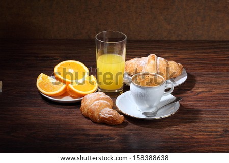 Fragrant fresh natural coffee with fresh orange juice and an appetizing croissant strewed by powdered sugar