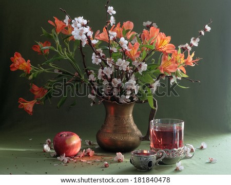 Still-life with an apple both fruit tea and a bright bouquet, fragrant fruit tea both a juicy ripe apple and a bright spring bouquet in a beautiful unusual jug