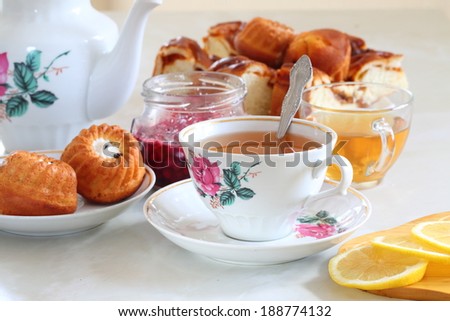 Still-life with fresh tea both a juicy lemon and a fragrant fresh batch, fragrant fresh tea with a juicy lemon and fresh rolls with a cream and a pie submitted with appetizing jam