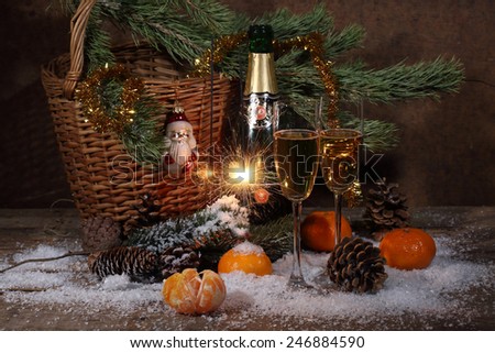 Champagne, tangerines, Bengal fire and fur-tree branch with cones under snow