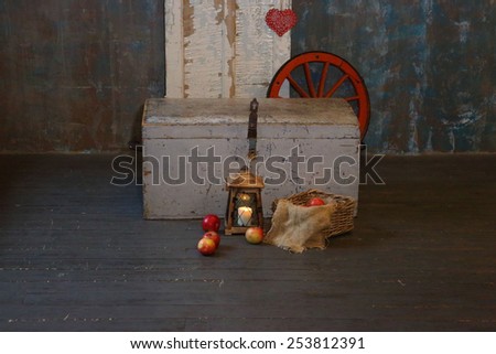 Apples in a wattled basket, a lantern and an old chest