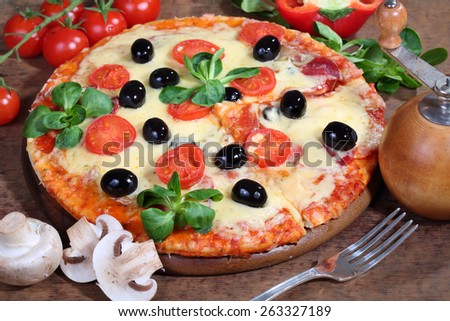 Pizza with cheese, a salami, field mushrooms and olives