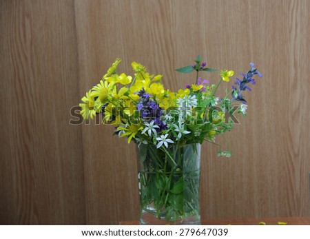 Bouquet of spring wild flowers in a transparent mug