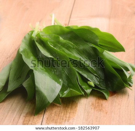 Fresh leaves of garlic on a wooden Board