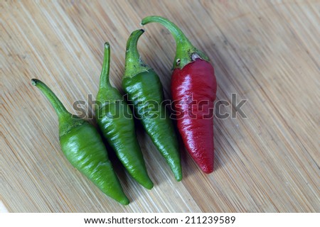 Red chilli with a group of green chilli, Being Different