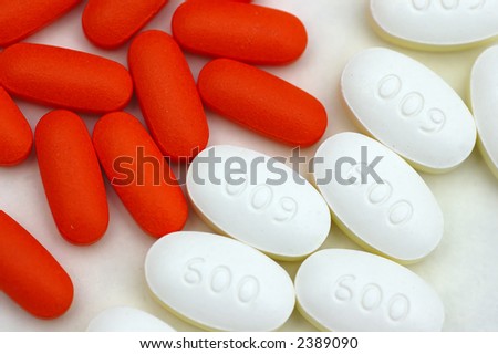 Closeup shot of Red and white pills against a white background
