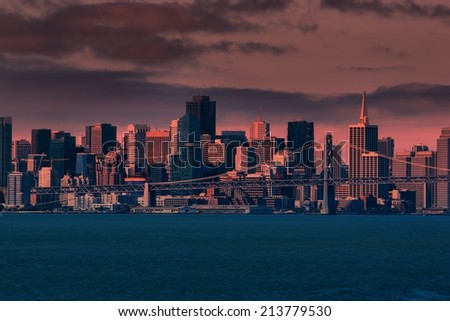 San Francisco Skyline and Financial District in morning light, viewed at a distance across the San Francisco Bay's waters.