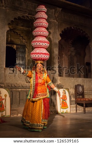 UDAIPUR, INDIA - NOVEMBER 24: Bhavai performance - famous folk dance of Rajasthan state of India. Performer balances number of earthen pots as she dance. November 24, 2012 in Udaipur, Rajasthan, India