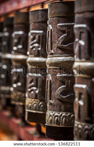 Tibetan Buddhist prayer wheels in Buddhism temple. Shallow depth of field. Rewalsar, HImachal Pradesh, India