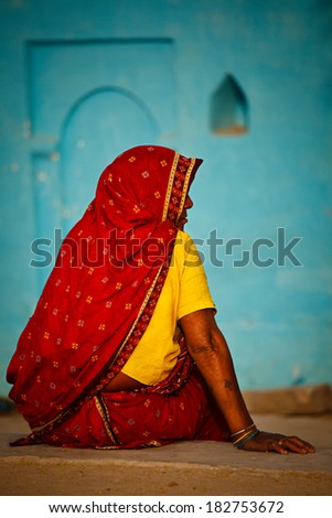 KHAJURAHO, INDIA - APRIL 15, 2011: Indian rural woman in traditional sari sitting in Khajuraho village. The major part of India rural population live the same traditional way as centuries before