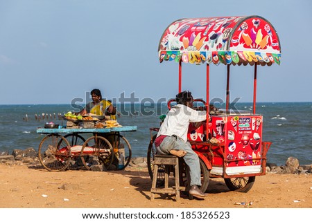 PONDICHERRY, INDIA - FEBRUARY 2, 2013: Unidentified Indian street vendors of ice cream and snacks with wheel carts on beach
