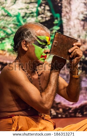 KOCHI, INDIA - FEBRUARY 24, 2013: Unidentified Kathakali exponent preparing for performance by applying face make-up. Kathakali is the classical dance form of Kerala