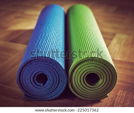 Vintage retro effect filtered hipster style image of Yoga mats on wooden floor